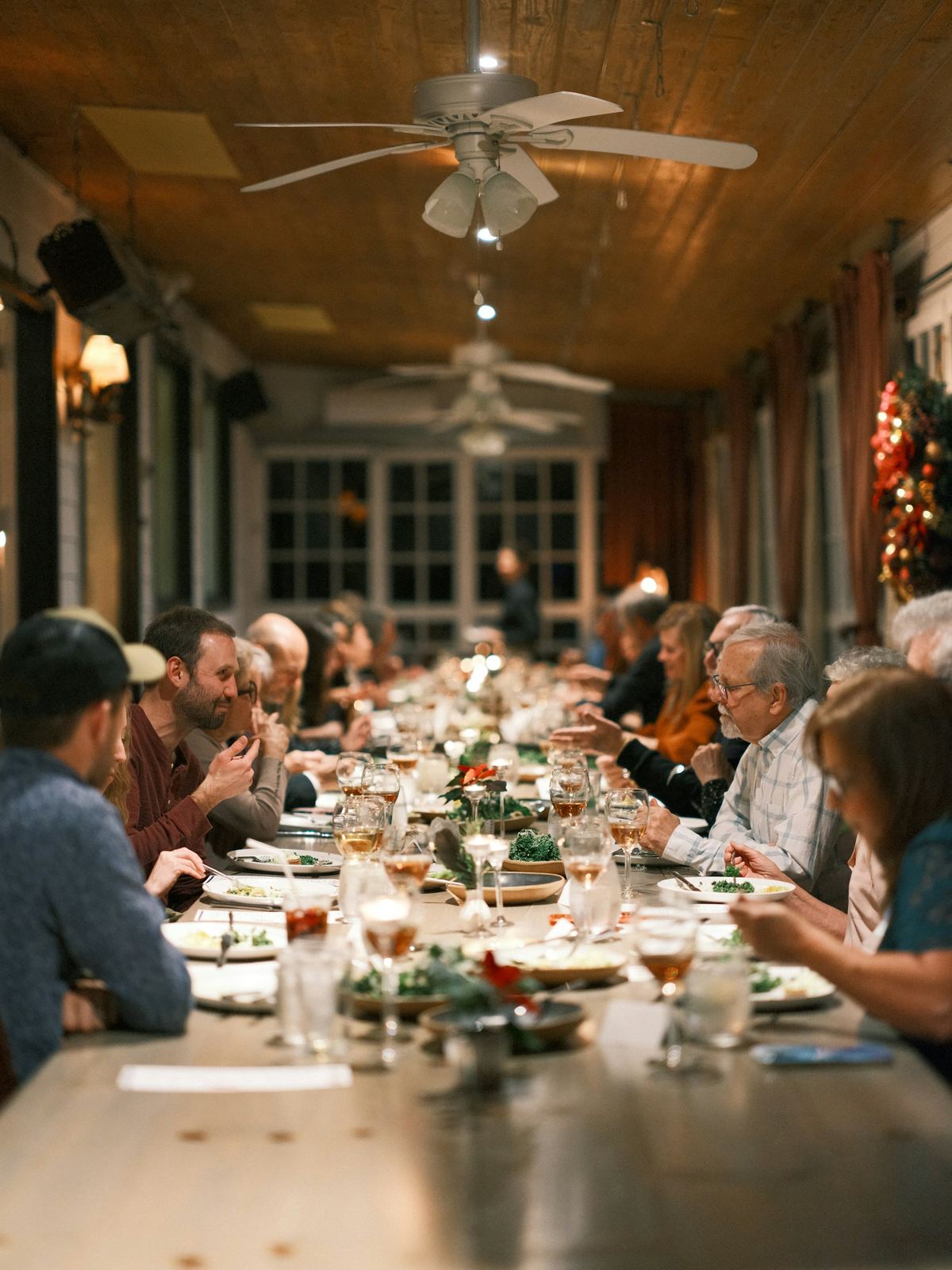 Una familia grande comiendo en una mesa larga