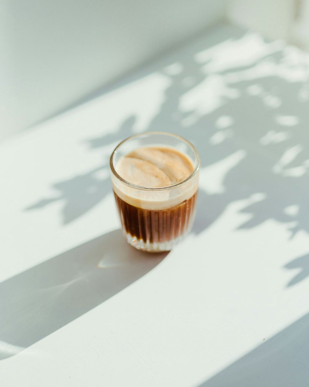 Un cortado en vaso de cristal, al sol de la mañana
