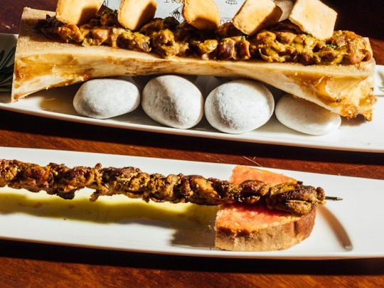 Tuétano asado y brocheta sobre pan con tomate