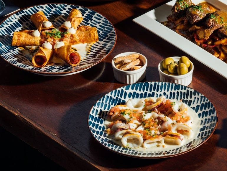 Calamares y flautas en platos de cerámica azul, con olivas y picos al lado