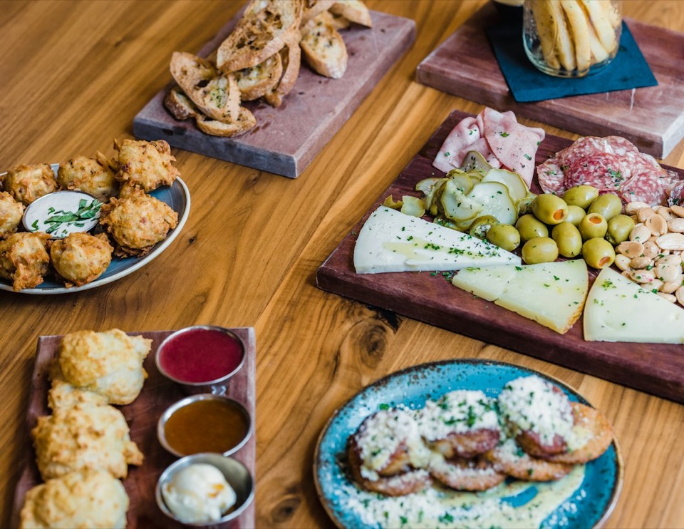 Mesa con buñuelos, queso, olivas y tostadas