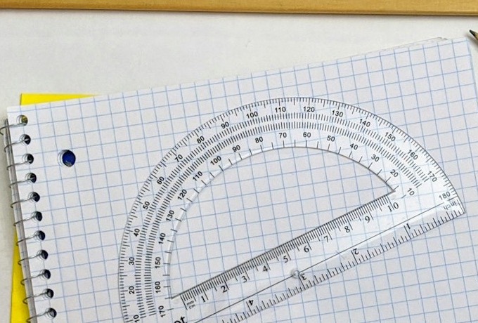 Cuaderno de cuadrícula con espiral y un transportador encima