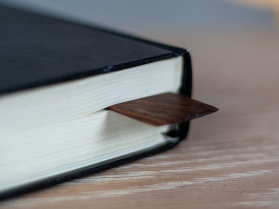 Esquina de un libro en tapa dura negra con un marcapáginas de madera