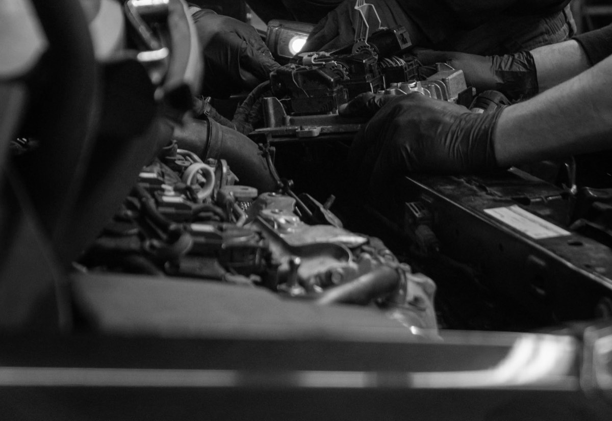 Manos con guantes revisando los conectores del motor